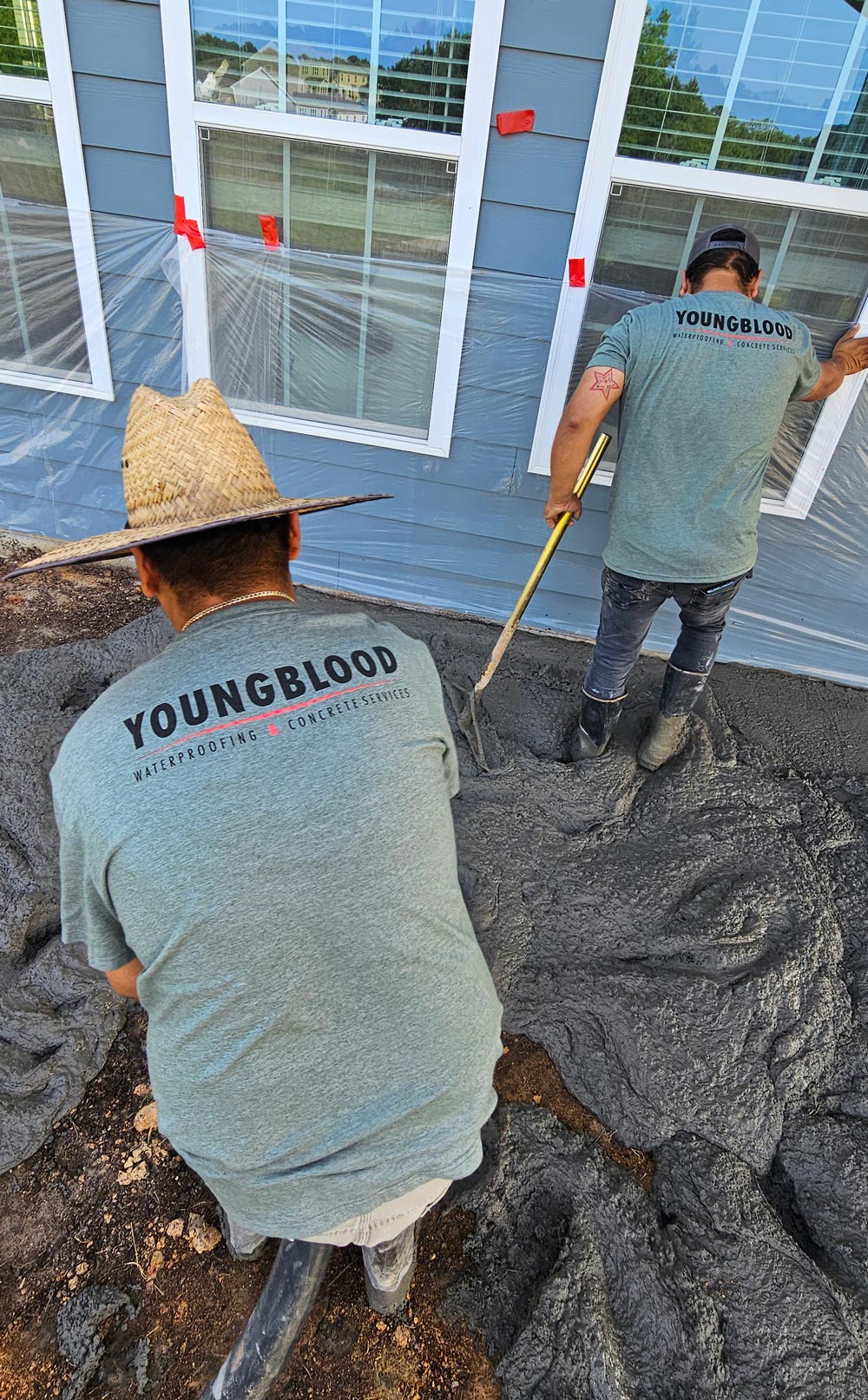 A wooden deck with a railing overlooks a grassy yard and bushes.