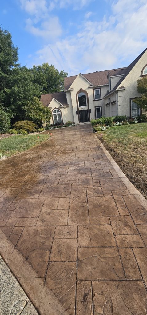 A large house with a stamped concrete driveway leading to the front entrance.